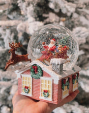 Load image into Gallery viewer, Musical Snow Globe. Plays Jingle Bells. beautiful snow globe. Santa in his sleigh upon the rooftop, with his reindeers leaping off the roof. Dimensions: 6.5&quot;H 7.25&quot;W 4.375&quot;L
