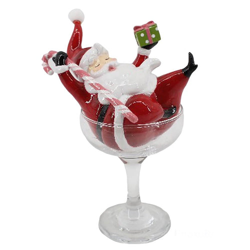 Retro Santa laying and playing in a Martini Glass.  He holds up a present and his candy cane.  Adorable Santa is sure to put on a smile on anyones face.  Perfect as a tabletop accent for all your parties drink table or bar.   Resin and Plastic Santa is 5